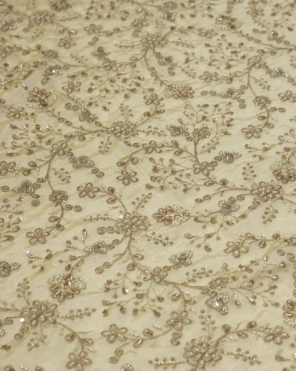 Cosmo silk fabric with gold zardozi and pearl bead embroidery on an ivory ground