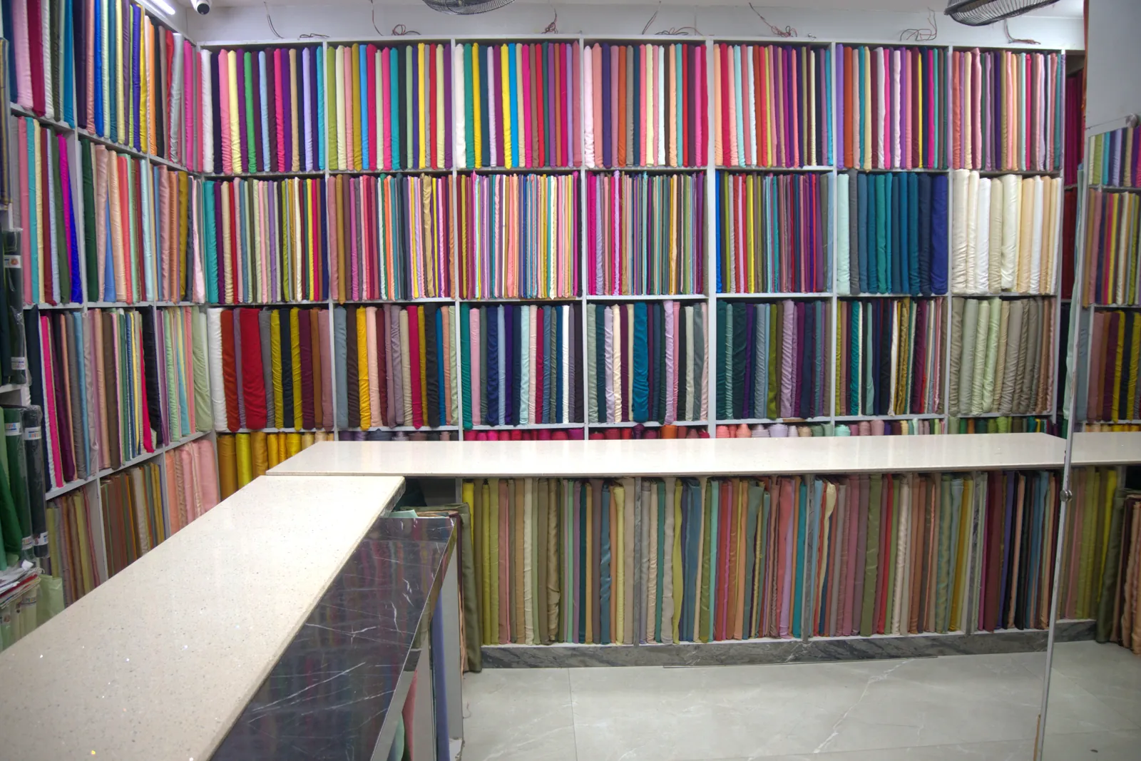 Wall of plain matching fabrics in hundreds of colours at the Rupam Sarees store, Sowcarpet